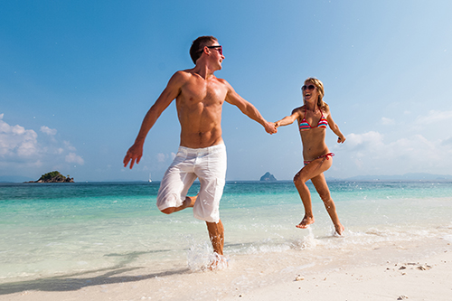 happy-young-couple-running-beach