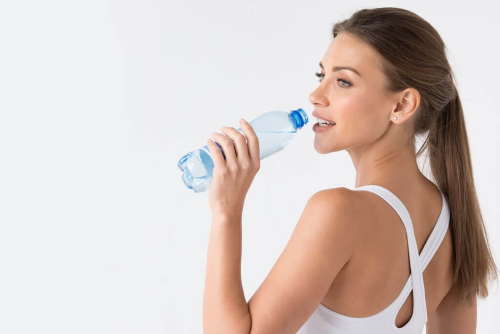 Woman with glowing skin drinking water