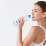 Woman with glowing skin drinking water