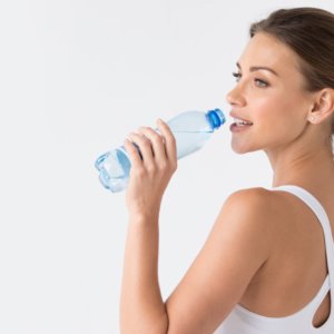 Woman with glowing skin drinking water